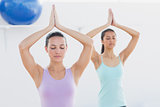 Sporty women with joined hands in fitness studio
