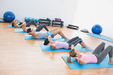 Determined people doing sit ups in fitness studio