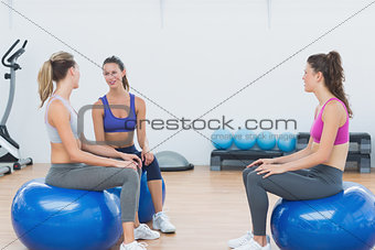 Sporty young women sitting on exercise balls