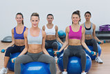 Women exercising with dumbbells on fitness balls