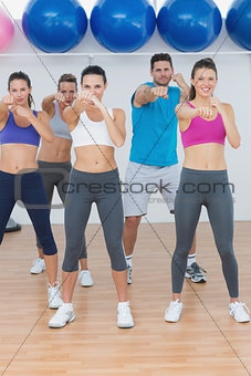 Smiling people doing power fitness exercise at yoga class