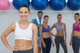 Female instructor with fitness class in background