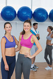 Fit women in sports bra with a couple in background