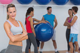 Fit young woman with friends in background at fitness studio