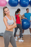 Young woman with friends in background at fitness studio