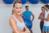 Smiling woman with friends in background at fitness studio