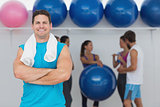 Smiling man with friends in background at fitness studio