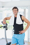Portrait of a smiling man at spinning class in bright gym