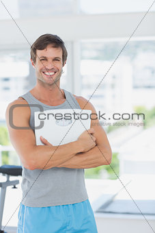 Fit man standing with scale in bright exercise room