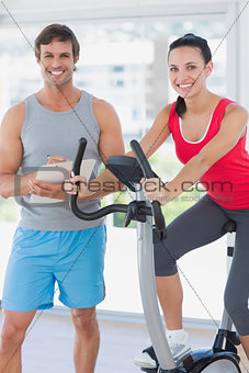 Woman with instructor working out at spinning class