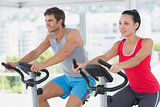 Fit young couple working out at spinning class