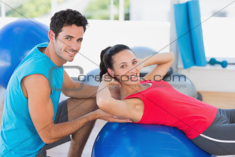 Male trainer helping woman with her exercises