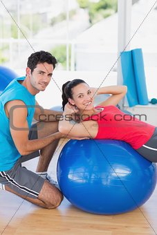 Male trainer helping woman with her exercises
