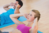 Side view of determined young couple doing sit ups