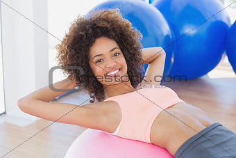 Fit young woman exercising on fitness ball