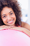 Portrait of a fit smiling young woman with fitness ball