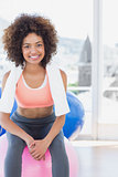 Fit young woman sitting on fitness ball at gym