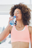 Fit female drinking water at gym