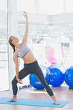 Fit woman stretching hand in fitness studio