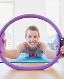 Smiling woman with exercising ring in fitness studio