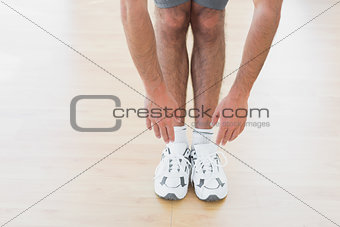 Man touching hands to feet in fitness studio