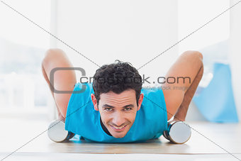 Man doing push ups with dumbbells in fitness studio