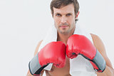 Portrait of a serious young man in red boxing gloves