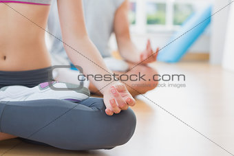 Sporty couple in meditation pose at fitness studio