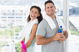 Couple with towels and water bottles at gym