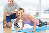 Woman doing push ups with trainer