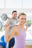 Woman lifting weights in fitness club
