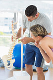 Instructor pointing on bone in the spine to woman