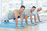 Fit men doing push ups at gym