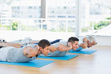 Men exercising on mats at gym