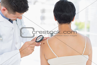 Dermatologist examining melanoma on woman