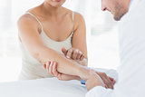 Male physiotherapist examining hand of woman