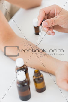 Physiotherapist dropping medicine on hand of woman