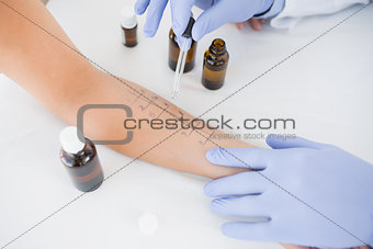 Doctor dropping medicine on hand of patient