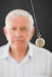 Senior man being hypnotized with pendulum