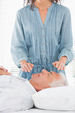 Therapist performing Reiki over face of man