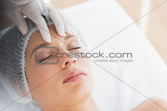 Woman recieving botox injection in forehead