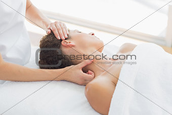 Woman receiving neck massage in spa