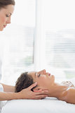 Therapist massaging woman in health spa