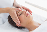 Woman receiving massage on forehead