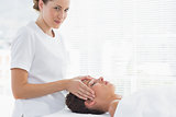 Therapist giving head massage to woman