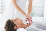 Therapist performing Reiki over woman
