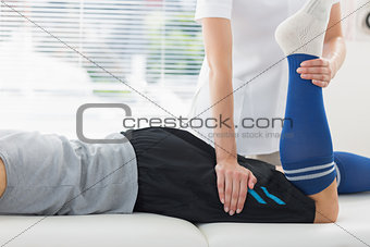 Physiotherapist working on leg of man