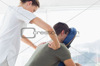 Physiotherapist giving back massage to man