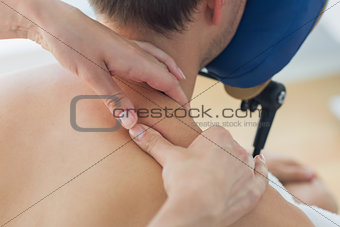 Man receiving shoulder massage by therapist
