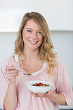 Young woman having cereals in kitchen
